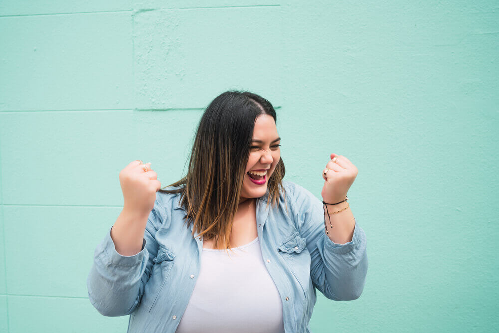 Woman in denim shirt with turquoise background